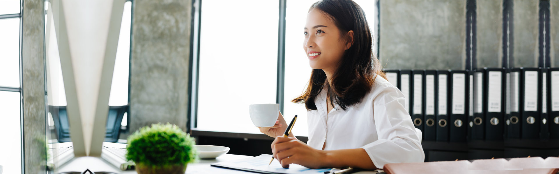 a businesswoman holding a cup while writing